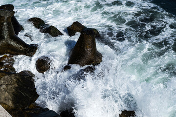 Sea waves crashing on rocks coast and the sea foam. Black sea, Constanta, Romania.