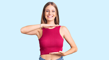 Fototapeta na wymiar Young beautiful blonde woman wearing elegant summer shirt gesturing with hands showing big and large size sign, measure symbol. smiling looking at the camera. measuring concept.