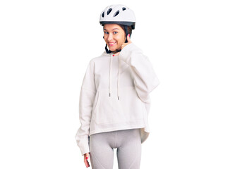 Beautiful brunette young woman wearing bike helmet and sporty clothes smiling doing phone gesture with hand and fingers like talking on the telephone. communicating concepts.