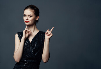 Woman shows her hands to the side on a gray background emotions advertising model