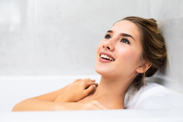 Young beautiful woman relaxing in bathtub at home