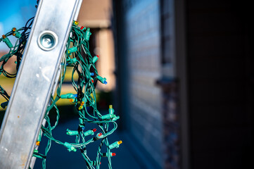 Selective focus on Christmas lights hanging off a ladder rung