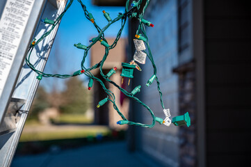 Selective focus on Christmas lights hanging off a ladder rung