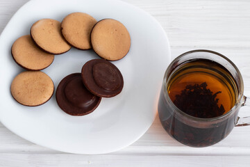 black tea in a Cup next to cookies on a white plate