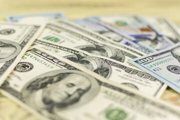 Hundred dollar bills on a wooden background.