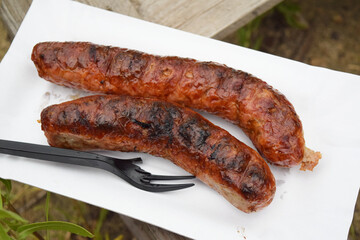 grilled sausages with plastic breaked fork