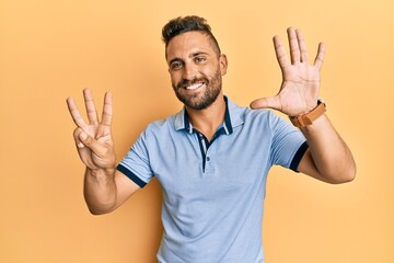 Fototapeta premium Handsome man with beard wearing casual clothes showing and pointing up with fingers number eight while smiling confident and happy.