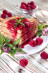 Pancake poured with raspberry jam on a platter