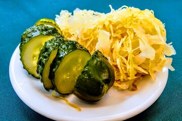 View of a plate with pickled cucumbers and cabbage.