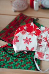 A close-up shot of Christmas designed disposable cotton face masks on the tailor's workplace. Hobby and Christmas concept