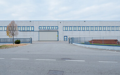 Fototapeta na wymiar industrial area in the suburbs, external view of unused concrete warehouses