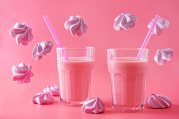 Pink milk cocktail in a glass with merengue cookies
