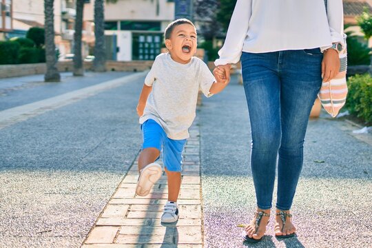 Adorable latin mother and son walking at the city.