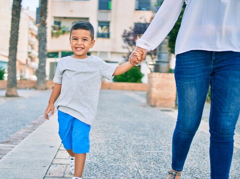 Adorable latin mother and son walking at the city.