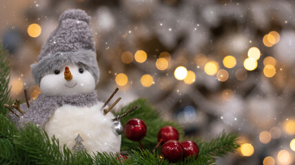 Christmas festive background, fir tree with bokeh lights and new year balls. Snowman on the background of New Year's lights.