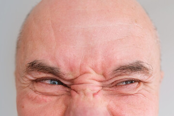 funny face of european adult man close up, wrinkles on aging skin, actor's grimaces, human emotions, mental illness