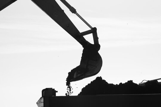 Silhouette image of Crane excavator at a construction site.