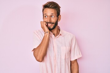 Handsome caucasian man with beard wearing casual pink shirt looking stressed and nervous with hands...