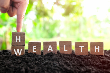 Health is wealth concept. Hand changing or flipping wooden blocks dice with word wealth to health...
