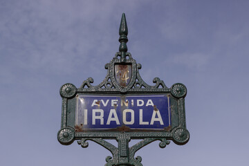 Old blue and white sign indicating Iraola avenue.