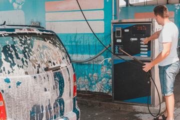 Foam on the car, car wash, self-service at the car wash, washing the car with foam.