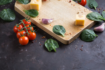 Fresh vegetables and cheese on a wooden background.