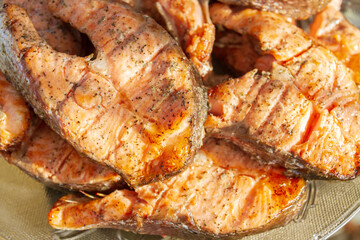 Grilled red fish trout steaks lie on a glass plate