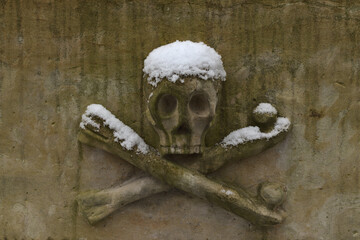A skull and crossed bones on a cemetery tomb symbolizing death