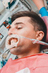 The procedure at the dentist,the dentist prepares the patient and tools to remove tartar, saliva ejector and retractor in the patient's mouth.