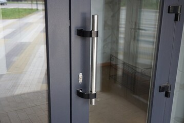 one gray metal door handle on plastic and glass door in the room