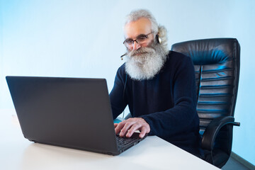 Correspondence consultation. Online course. Remote consultations. Elderly man with a beard communicates with customers via the Internet. The teacher communicates with students online.