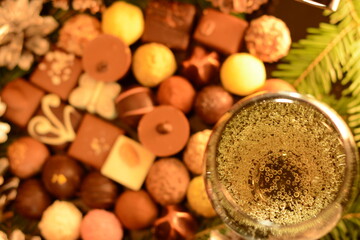 Glass with champagne and assorted chocolates, top view