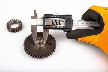 Measuring the gears with a caliper. Engineering work in the laboratory.