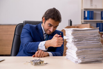Young male employee burning papers in the office