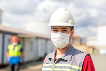 Worker is using a protective face mask for coronavirus and looking at the camera in the...