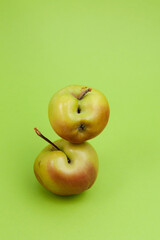 Ugly apples with flaws on green background, close-up. Selective focus, copy space. Concept - Food waste reduction. Using in cooking imperfect products
