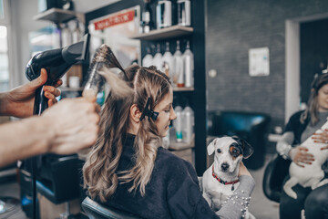 Beautiful hairstyle of woman after dyeing hair and making highlights in hair salon.
