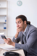 Naklejka premium Young male bookkeeper calculating expences