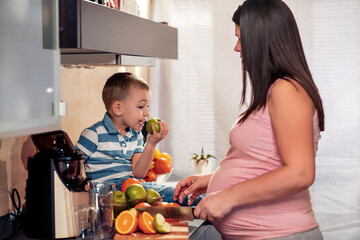 Family in the kitchen make fresh juice.