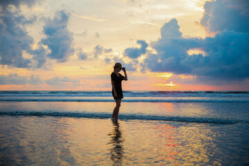 Fototapeta premium Silhouette of a woman on the background of sunset on the Kuta beach