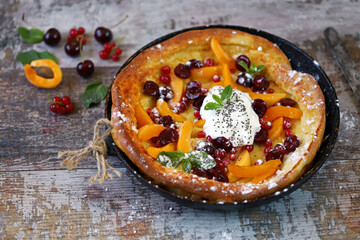 Selective focus. Macro. Dutch baby pancake with berries and yogurt. Delicious popular dessert.