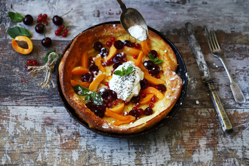 Selective focus. Macro. Dutch baby pancake with berries and yogurt. Delicious popular dessert.