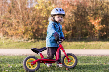 petite fille en draisienne en automne