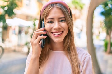 Young caucasian girl smiling happy talking on the smartphone at the city.