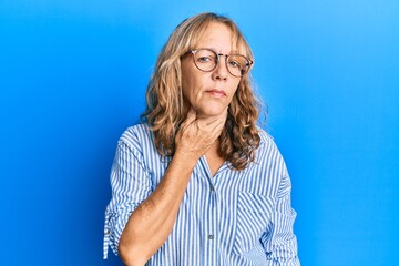 Plakat Middle age blonde woman wearing casual clothes and glasses touching painful neck, sore throat for flu, clod and infection