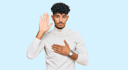 Young arab man wearing casual winter sweater swearing with hand on chest and open palm, making a...