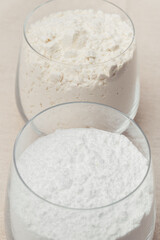 Glass of flour and glass of powdered sugar close-up. Macro shot. Selective focus.