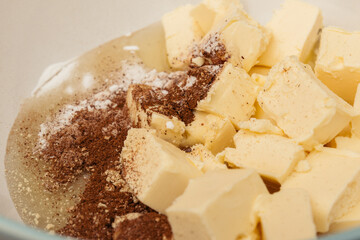 Pieces of butter and honey covered by cinnamon powder and sugar. Macro shot. Selective focus.