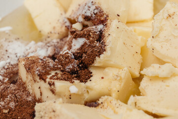 Pieces of butter covered by cinnamon powder and sugar. Macro shot. Selective focus.