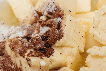 Pieces of butter covered by cinnamon powder and sugar. Macro shot. Selective focus.